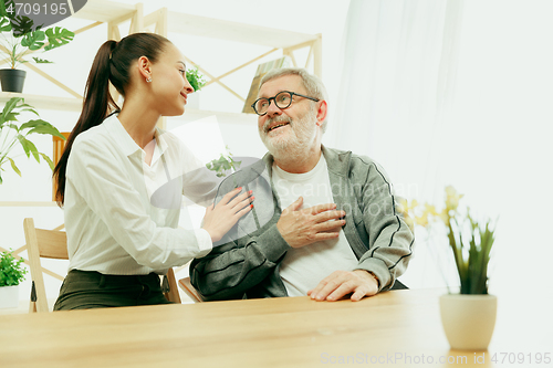 Image of A daughter or granddaughter spends time with the grandfather