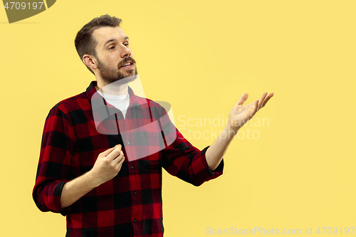 Image of Half-length close up portrait of young man on yellow background.