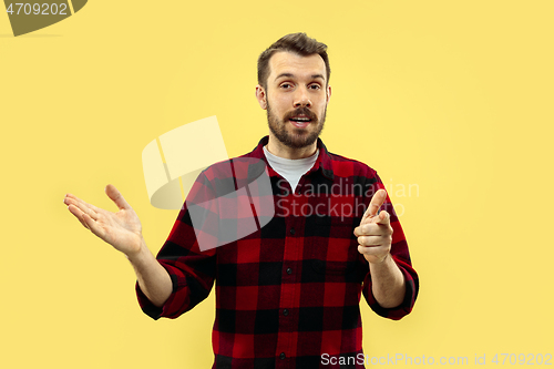 Image of Half-length close up portrait of young man on yellow background.