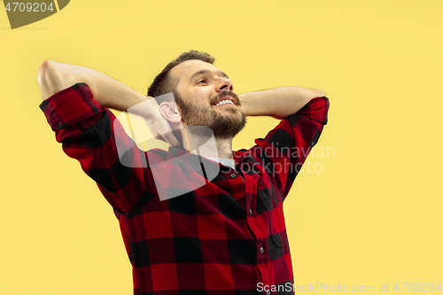 Image of Half-length close up portrait of young man on yellow background.