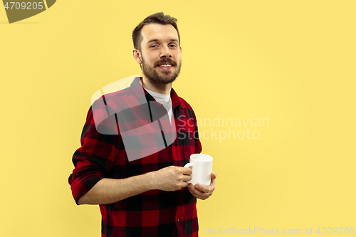 Image of Half-length close up portrait of young man on yellow background.