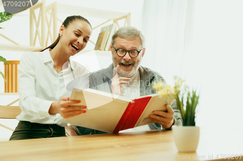 Image of A daughter or granddaughter spends time with the grandfather