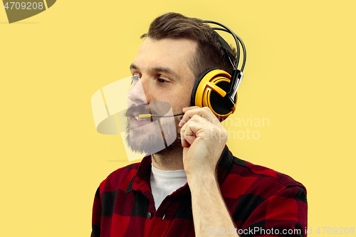 Image of Half-length close up portrait of young man on yellow background.