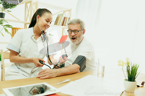 Image of The visiting nurse taking care of senior man