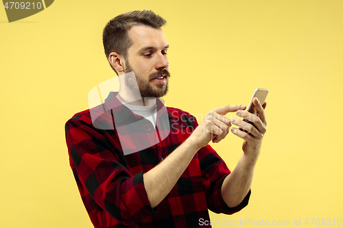 Image of Half-length close up portrait of young man on yellow background.