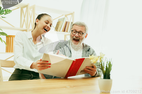 Image of A daughter or granddaughter spends time with the grandfather