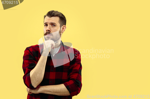 Image of Half-length close up portrait of young man on yellow background.