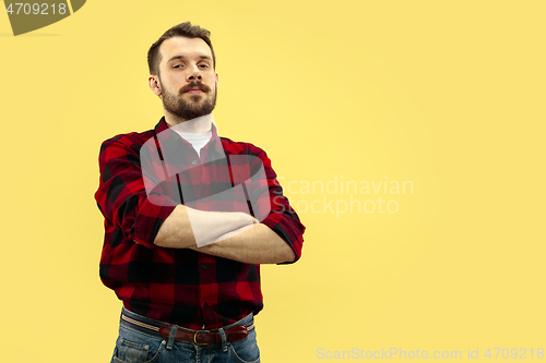 Image of Half-length close up portrait of young man on yellow background.