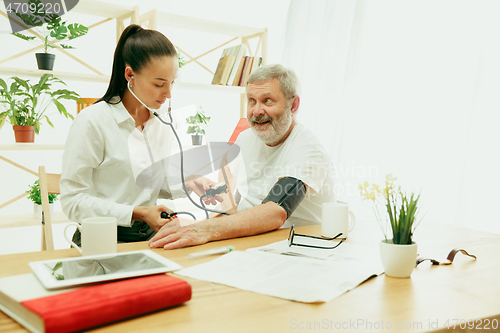 Image of The visiting nurse taking care of senior man