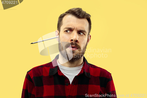Image of Half-length close up portrait of young man on yellow background.