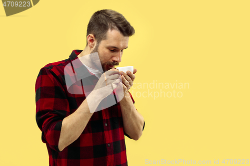 Image of Half-length close up portrait of young man on yellow background.