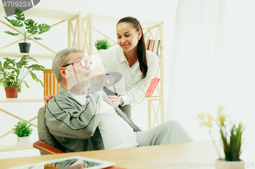 Image of A daughter or granddaughter spends time with the grandfather