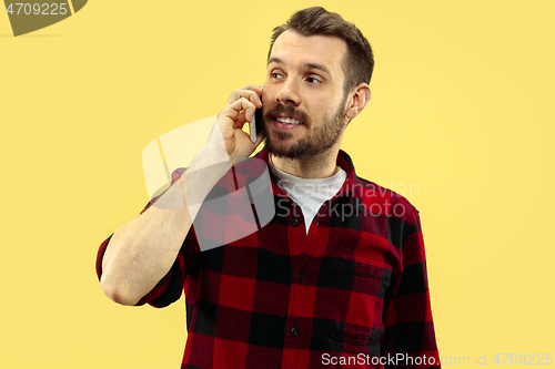 Image of Half-length close up portrait of young man on yellow background.