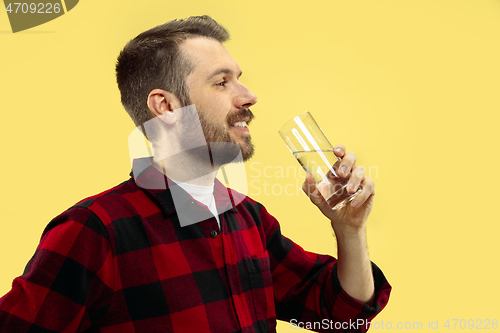 Image of Half-length close up portrait of young man on yellow background.