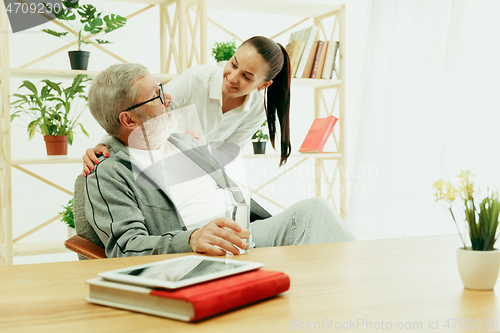 Image of A daughter or granddaughter spends time with the grandfather