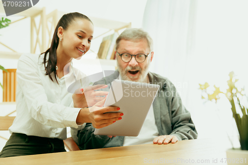 Image of A daughter or granddaughter spends time with the grandfather