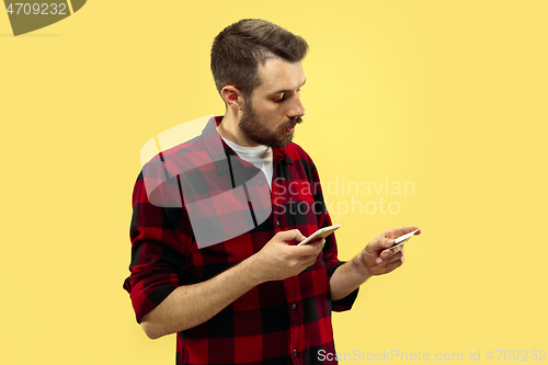 Image of Half-length close up portrait of young man on yellow background.