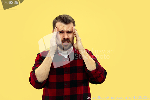 Image of Half-length close up portrait of young man on yellow background.