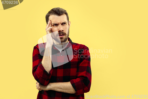 Image of Half-length close up portrait of young man on yellow background.