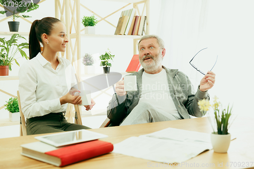 Image of A daughter or granddaughter spends time with the grandfather