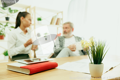 Image of A daughter or granddaughter spends time with the grandfather