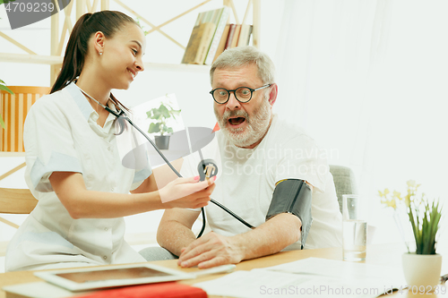 Image of The visiting nurse taking care of senior man