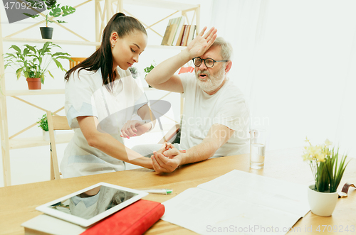 Image of The visiting nurse taking care of senior man