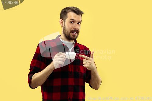 Image of Half-length close up portrait of young man on yellow background.