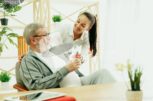 Image of A daughter or granddaughter spends time with the grandfather