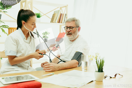 Image of The visiting nurse taking care of senior man