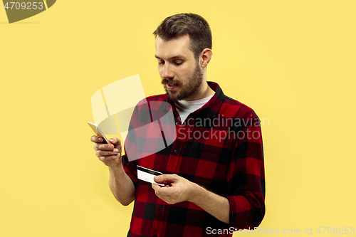 Image of Half-length close up portrait of young man on yellow background.