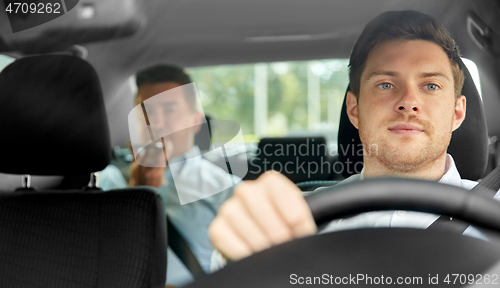 Image of male taxi driver driving car with passenger