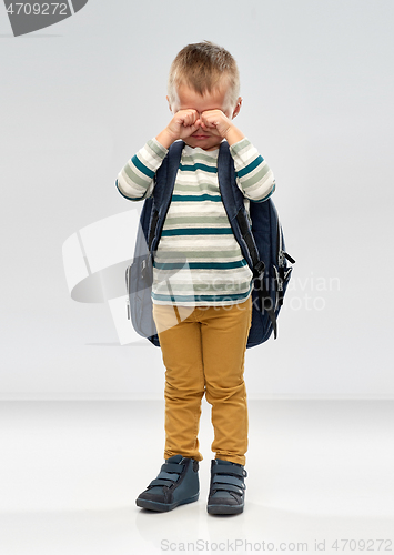 Image of crying little boy with school backpack