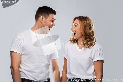 Image of portrait of laughinh couple in white t-shirts