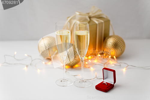 Image of champagne and diamond ring in box on christmas