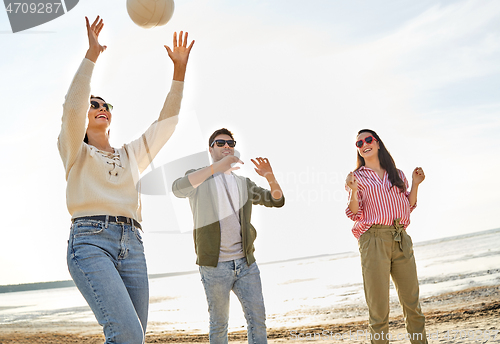 Image of friends playing volleyball on beach in summer