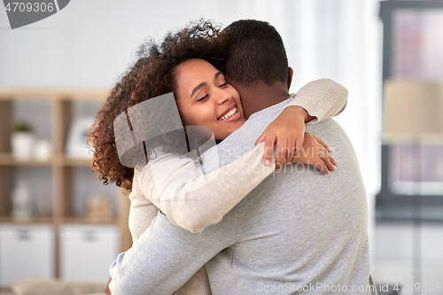 Image of happy african american couple hugging at home