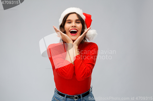 Image of happy young woman in santa hat on christmas