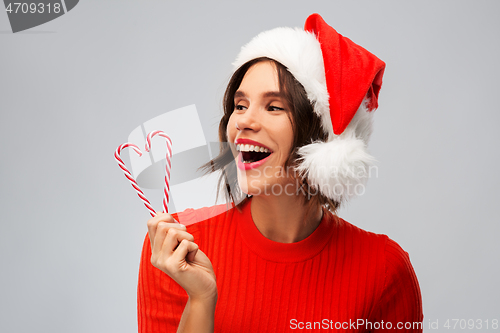 Image of happy young woman in santa hat on christmas