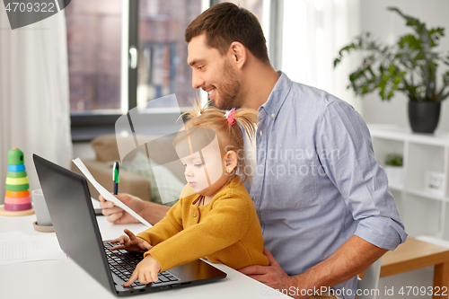 Image of working father with baby daughter at home office