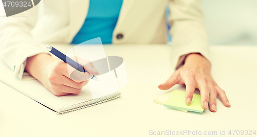 Image of close up of woman with to notepad at office