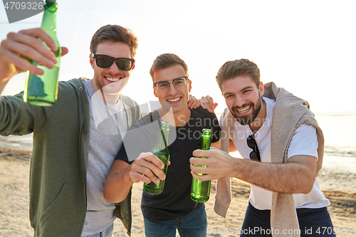 Image of young men toasting non alcoholic beer on beach