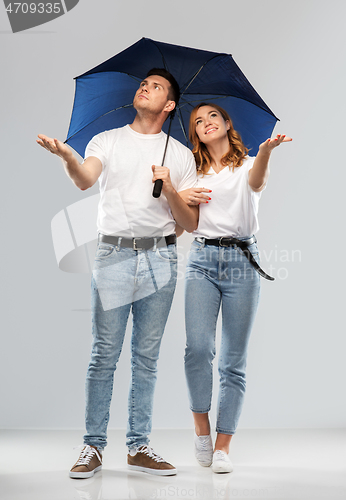 Image of happy couple in white t-shirts with umbrella