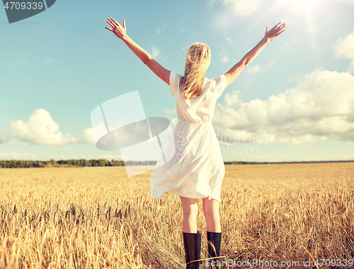 Image of happy young woman in white dress on cereal field