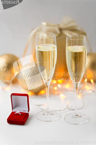 Image of champagne and diamond ring in box on christmas