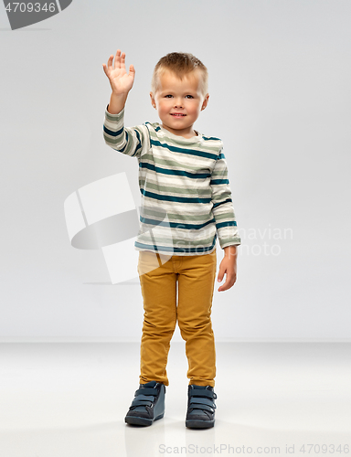 Image of little boy in striped shirt waving hand