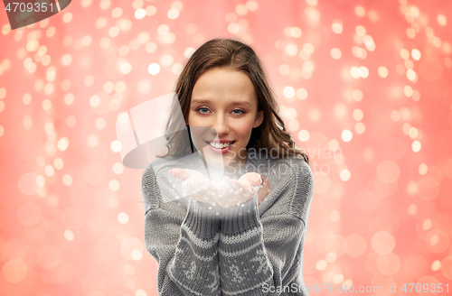 Image of young woman in christmas sweater with fairy dust