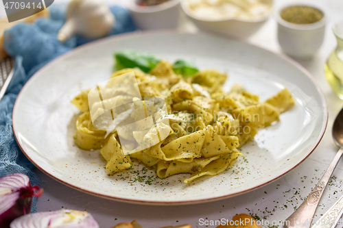 Image of Cooked homemade pasta with pesto, fresh basil, mozarella cheese and herbs