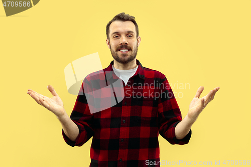 Image of Half-length close up portrait of young man on yellow background.