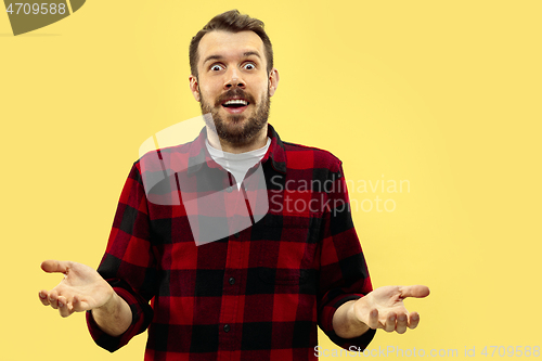 Image of Half-length close up portrait of young man on yellow background.